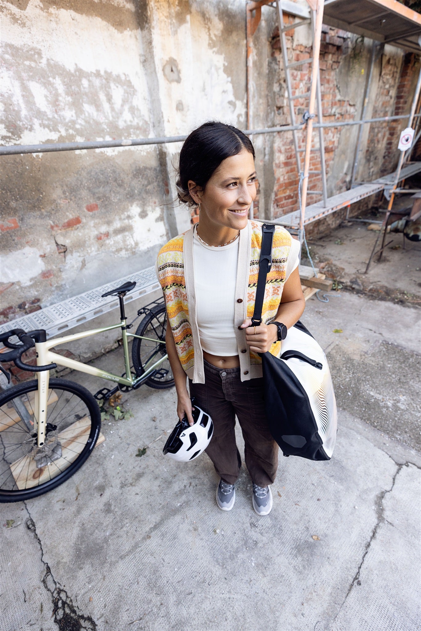 Frau trägt ORTLIEB Back-Roller Design Tasche in Route No.1 mit gelb-orangen Linienmuster
