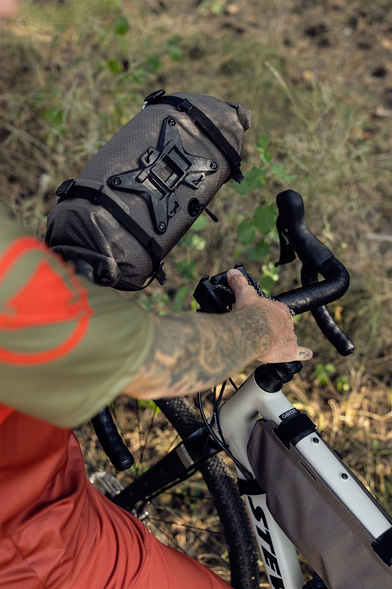 Radfahrer mit ORTLIEB Handlebar-Pack Flex in dark-sand auf Waldweg unterwegs